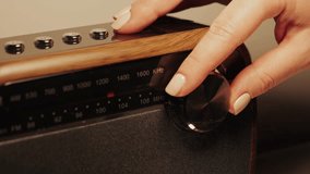 Close-up of a radio dial. A hand turns the tuning knob. Tuning a radio station frequency. High quality 4k footage - Powered by Shutterstock - Get 15% off with code: PIKWIZARD15