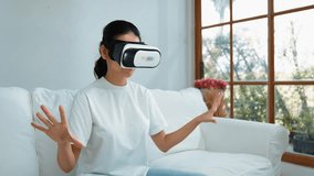 Young woman using virtual reality VR goggle at home for vivancy online shopping experience. The virtual reality VR innovation optimized for female digital entertainment lifestyle. - Powered by Shutterstock - Get 15% off with code: PIKWIZARD15