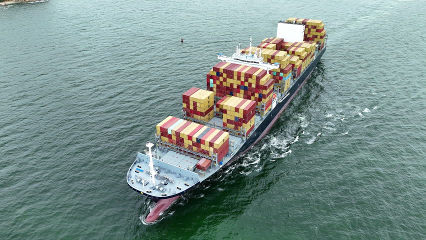 Aerial top view of a large cargo ship fully loaded with colorful shipping containers navigating through calm ocean water. Ideal for logistics, transport, and global trade concepts.