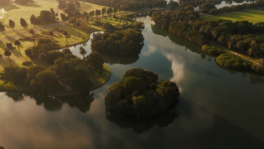 Golden light hitting lake and tree reflections in Centennial Park during sunrise or sunset, orbit, Sydney NSW Australia