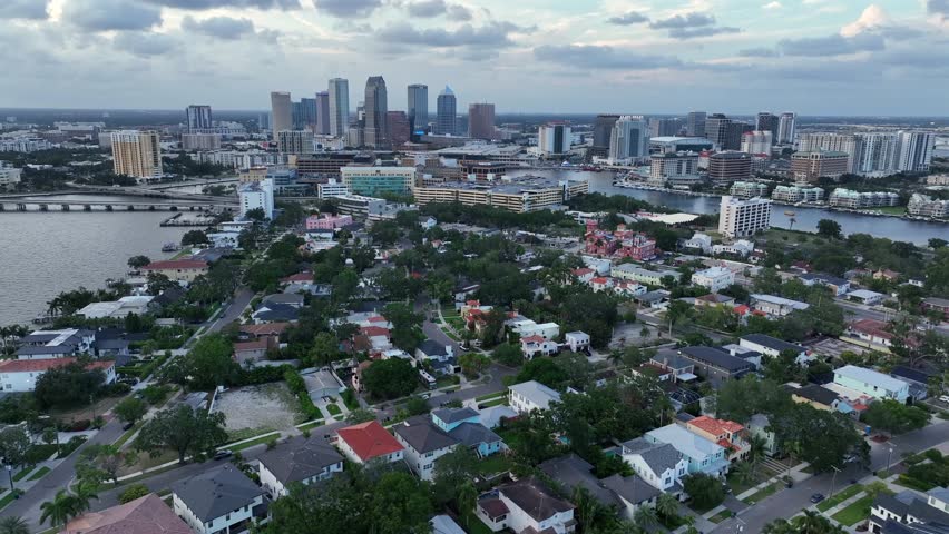 Housing area of Tampa City with Skyline in distance. Aerial wide shot. Clouds at sky. Colored houses in suburbia between rivers and bridges. Florida, United States.