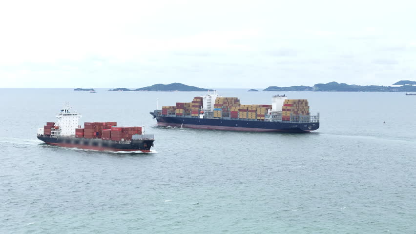 Aerial view of Two 2 Large Cargo Ship carrying container and running in Opposite direction for export import Cargo. Two large container ships sail across calm ocean 