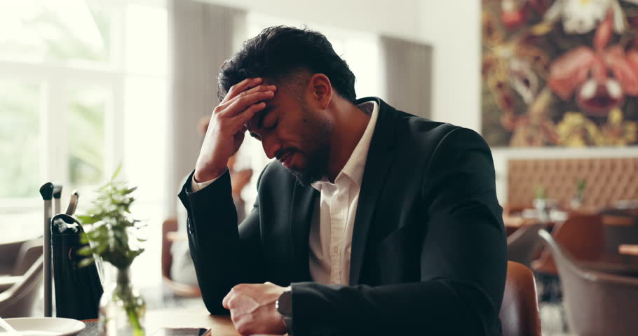 Travel, luggage and business man with headache in restaurant for flight delay, stress or pain. Work trip, person or migraine in airport lounge for missed departure, meeting deadline or massage temple