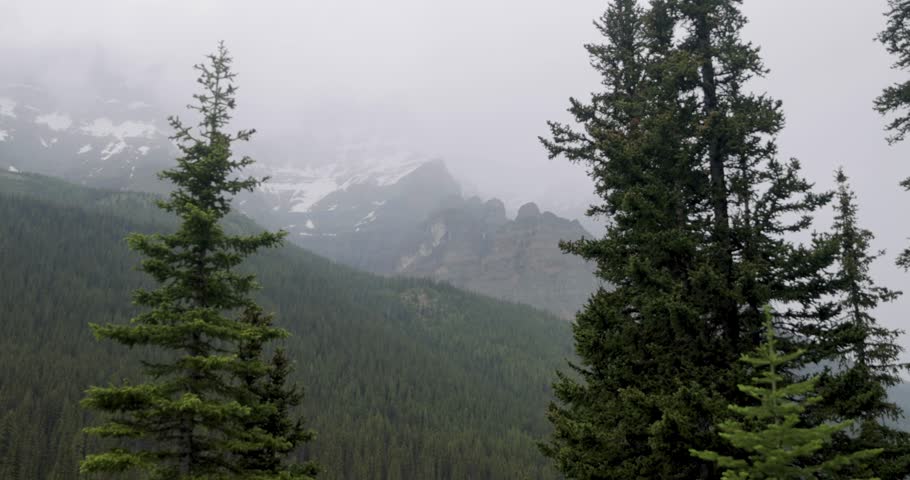 View of the mountain range surrounding Moraine Lake in Banff National Park Alberta on a slightly foggy afternoon.