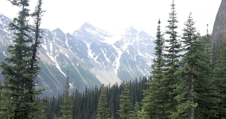 Beautiful view of a mountain range with snow on it from the hiking trail up to Lake Agnes Tea House on Mount St. Piran and Mount Whyte, within Banff National Park near Lake Louise Alberta.