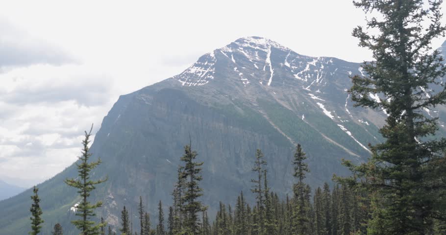 View of the mountain range surrounding Moraine Lake in Banff National Park Alberta on a slightly foggy afternoon.