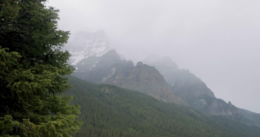 View of the mountain range surrounding Moraine Lake in Banff National Park Alberta on a slightly foggy afternoon.