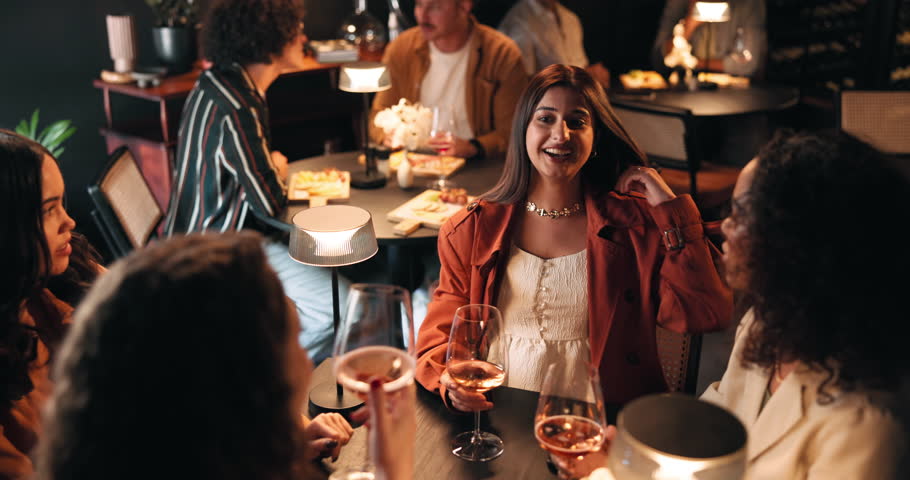 Girls night, laughing and toast with friends in restaurant for bonding, reunion or social gathering. Cheers, fine dining and wine with group of people at table together for evening catch up or drinks