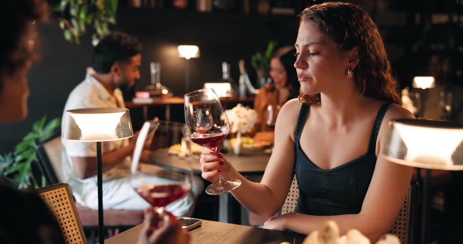Couple, night or drinking wine in restaurant with date for romantic dinner, anniversary or occasion. Man, woman or tasting alcohol in late evening with meal for fine dining, romance or rendezvous