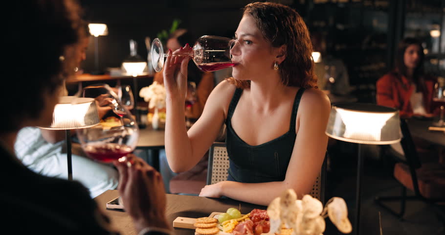 Conversation, wine and woman on date in restaurant for love, bonding or anniversary celebration. Talking, fine dining and couple with alcohol drink at romantic dinner for relationship at diner.