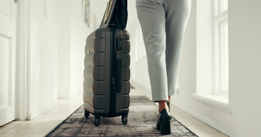 Business, legs or walking with suitcase to hotel room for accommodation, guest arrival or check in. Corporate trip, back or woman with luggage in lodge corridor for booking reservation or hospitality