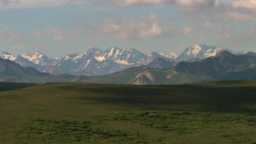 Distant View of Snow-Covered Alaska Range under Partly Cloudy Sky