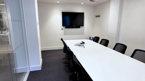 Large conference room with minimalistic design, equipped with furniture and technology tools. Pan Right - Powered by Shutterstock - Get 15% off with code: PIKWIZARD15