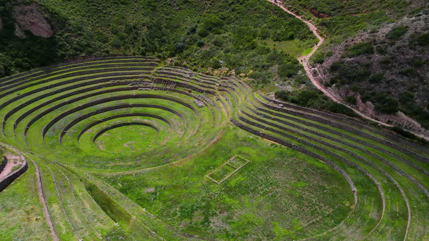 Aerial approach and orbit of Moray’s iconic circular Inca terraces in Peru, revealing the ancient agricultural concentric design in the Sacred Valley