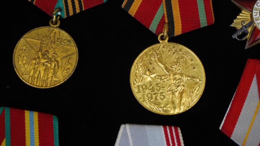 medals lying on a black surface with visible inscriptions and symbols