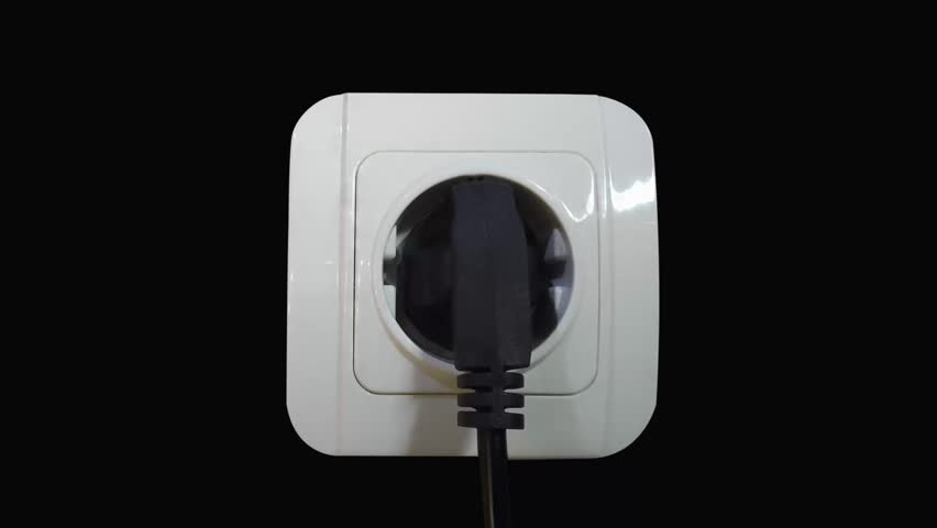 a white electrical socket and a black plug plugged in with a white smoke effect. short-circuited electrical equipment