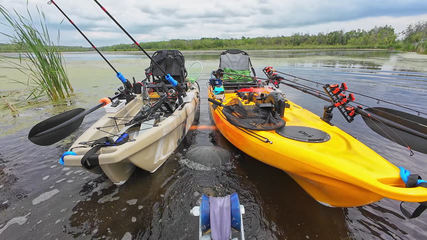 Truck pulling boat trailer out of fishing kayaks, boat launch at lake in the wilderness. Boat trailer with fishing kayaks near drop off at the lake. Water access with trailer attached to hitch mount.