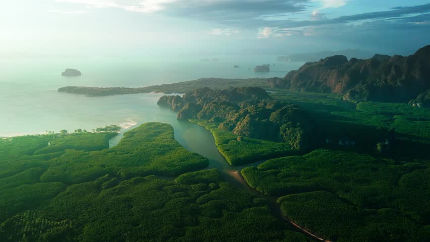 Spectacular slow motion drone footage showing a sunrise aerial panorama over Krabi dramatic limestone mountains, mangroves, and rural landscapes-perfect for cinematic and travel footage.