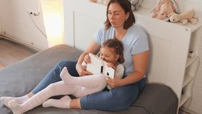 Beautiful woman and her little girl enjoy reading a story together in bed. Concept of child learning, maternal care, and speech development at home. Top view - Powered by Shutterstock - Get 15% off with code: PIKWIZARD15