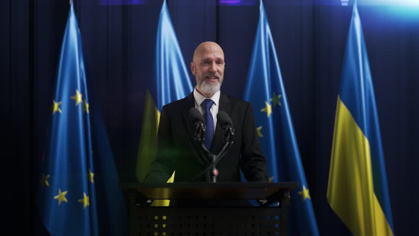A politician gives a happy speech with flags of EU and Ukraine on background