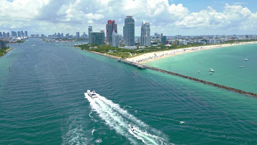 Miami skyline from above. Luxury yacht in Miami. Aerial view of Miami South Beach. Boats along the Miami coast. Oceanfront city panorama. Drone flying over city. .Sunny day in Florida. South Point.