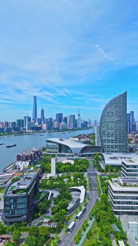 Shanghai, China - July 2nd 2025: 4K real time Aerial view of Shanghai skyline and winding river on sunny day, with blue sky background.