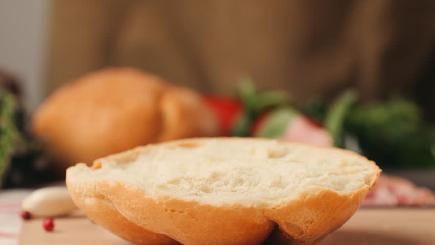 Mortadella ham sandwich, Traditional italian focaccia filled with thin pesto slices of mortadella, served by chef man in cafe restaurant. Macro of traditional italian spanish tapas antipasti. 