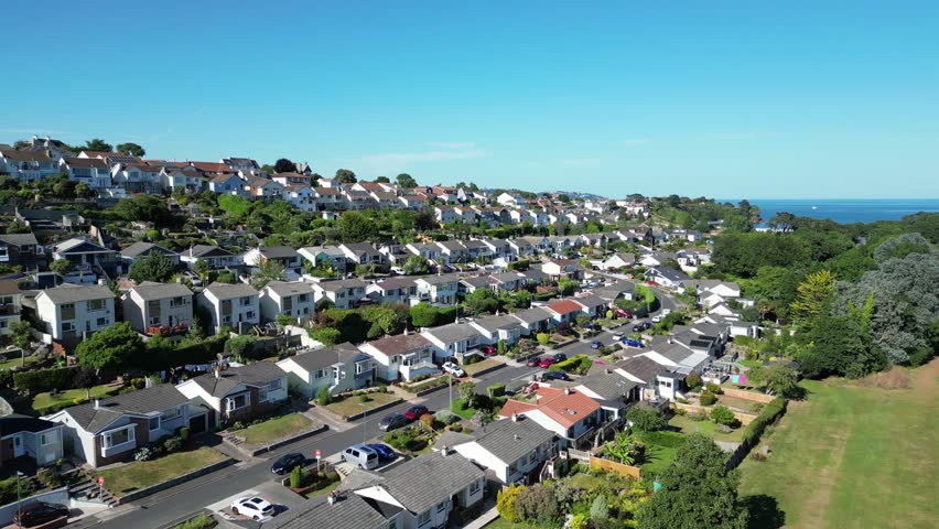 Paignton, Torbay, Devon, England: DRONE VIEWS: The drone flies over suburban houses to reveal the coastline and sea. Torbay is a popular UK holiday destination and retirement area (2).