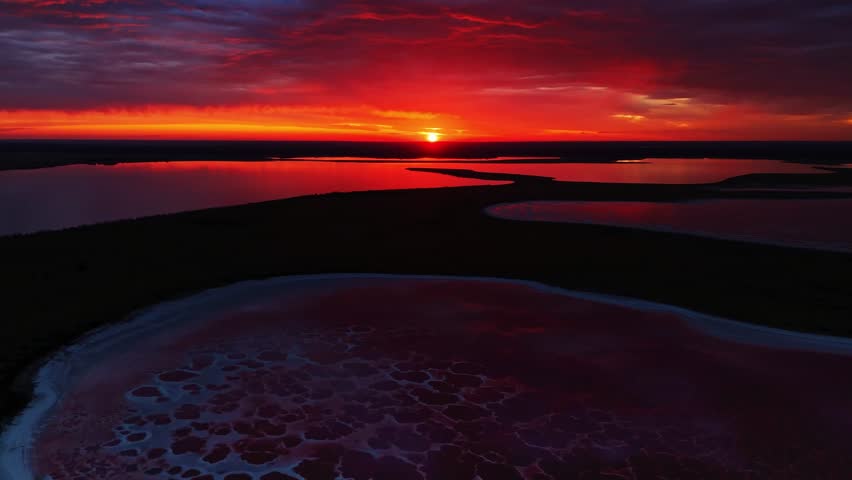 A breathtaking sunset casts its enchanting glow over the serene wetlands, showcasing vibrant colors