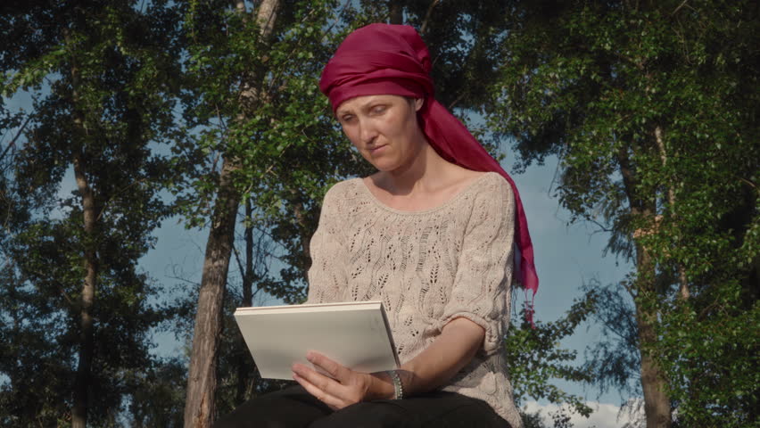 Female artist painting river landscape with watercolor while sitting on wooden pier