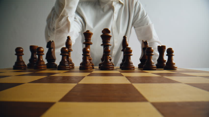 Unknown grandmaster playing chess at home. Man hand making first move brainstorming tactics. Unrecognizable player enjoy chessboard mind game tournament moving piece thinking. Checkmate sport concept 