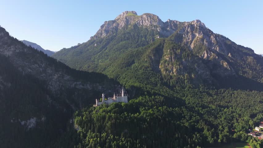 Neuschwanstein Castle in the Bavarian Alps, Germany, Summer landscape - view of the famous tourist attraction in the Bavarian Alps - the 19th century Neuschwanstein castle among green mountains