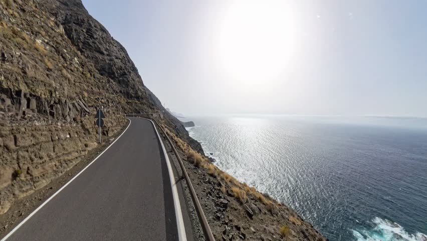 360 view of scenic coastal mountain road GC-200 in Gran Canaria, filmed from moving car on a sunny day with rotating camera movement, drone-like travel footage, Canary Islands, Spain