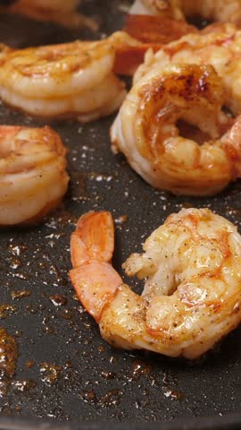 Cooking big shrimps on frying pan. Preparation langoustines. Closeup. Top view. Vertical footage