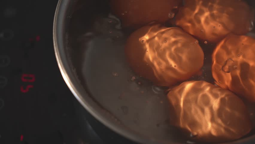 Dolly top view of brown eggs boiling in kitchen pot