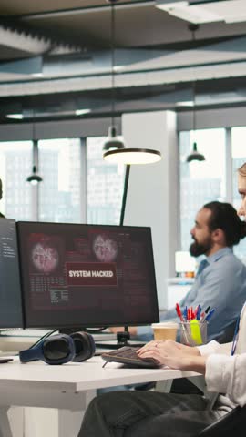 Vertical video Young inexperienced developer in office requests help from team to fix hacking attempt on corporate network. Intern assisted by colleagues to investigate unauthorized access alerts