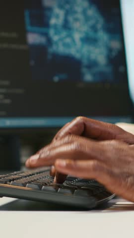 Vertical video System administrator at office desk developing software applications using AI automation. IT specialist working on computer, debugging applications with artificial intelligence, camera
