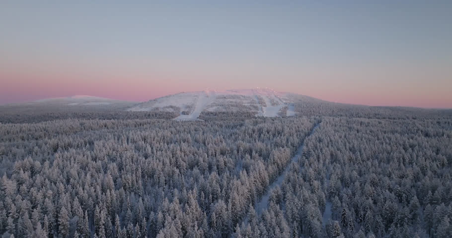 Aerial view orbiting the frosty Sallatunturi mountain, polar night in Lapland