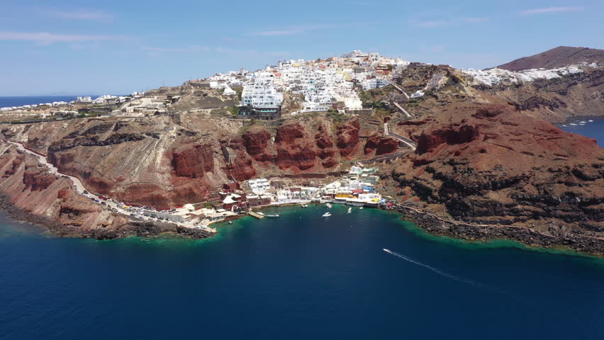 Monolíthou Marina On Sheer Rock Face Sea Cliffs In Mediterranean Sea, Santorini, Greece. Aerial Drone Shot