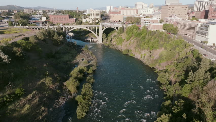 Aerial shot of downtown Spokane featuring the Monroe Street Bridge crossing the river below the city skyline.