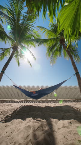 Vertical Screen: Imagine a serene scene of a person lounging in a hammock, surrounded by palm trees and a sunny beach, perfect for showcasing ultimate relaxation and tropical holiday vibes
