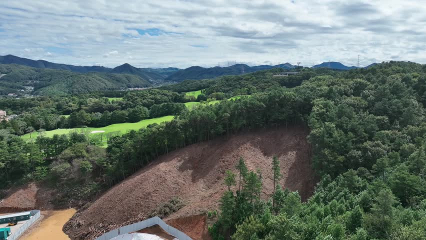 Aerial View of Lush Green Golf Course in Forested Mountain Landscape