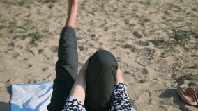 On a summer morning, an elderly woman lies on her back by the sandy lake, one knee to chest, the other slowly rising. The movement builds strength, improves flexibility, and keeps her joints mobile. - Powered by Shutterstock - Get 15% off with code: PIKWIZARD15