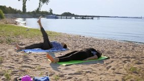 On a summer day by a scenic lake, a woman and her adult daughter slowly lift their legs, hold, then lower in a stretching routine. Moving outdoors eases tension and boosts flexibility. - Powered by Shutterstock - Get 15% off with code: PIKWIZARD15