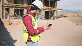 On a construction site, a worker in a hard hat, safety vest, and earbuds sways while scrolling through his phone in search of a track. Curating his playlist, e sets the rhythm for a productive day. - Powered by Shutterstock - Get 15% off with code: PIKWIZARD15