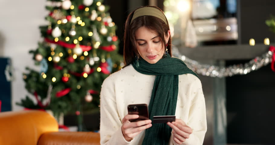 Credit card, christmas and woman in home with phone for online shopping with festive season deals. Debit, cellphone and female person with ecommerce store for xmas discount in living room at house.