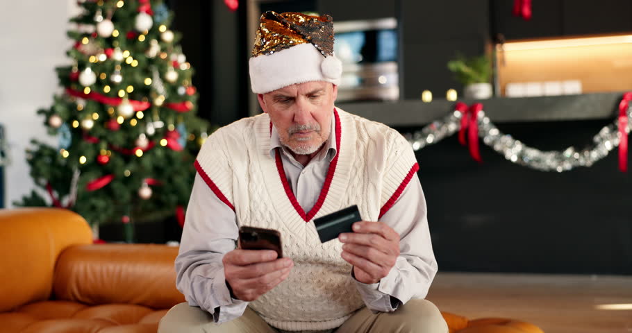 Credit card, christmas and mature man in home with phone for online shopping with festive season deals. Debit, cellphone and male person with ecommerce store for xmas discount in living room at house