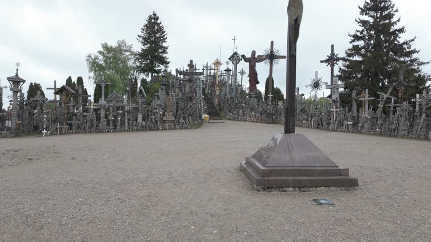 A serene wide shot of Cross Hill in Siauliai Lithuania featuring countless crosses and religious symbols smooth motion dynamic movement cinematic quality