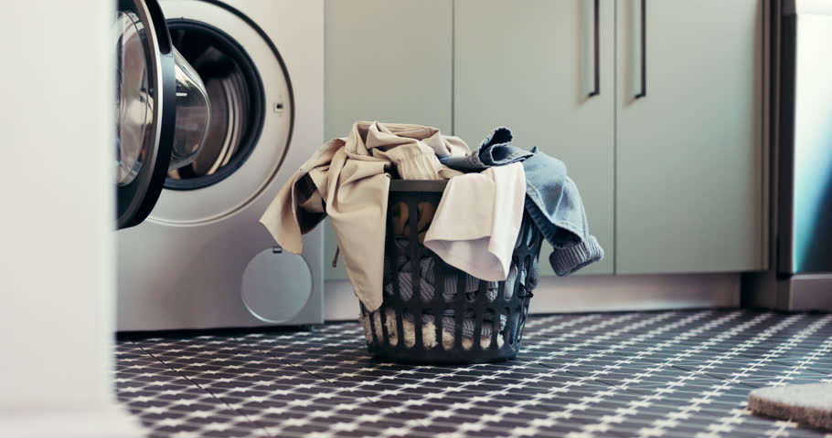 Laundry, washing machine and basket with clothes in home for maintenance, housework or hygiene. Empty, apartment and container with textiles, fabric and material for housekeeping, cleaning or chores