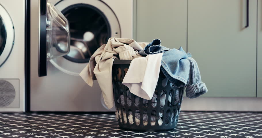 Laundry, washing machine and basket with clothes on floor for maintenance, housework or hygiene. Empty, apartment and container with textiles, fabric and material for housekeeping, cleaning or chores